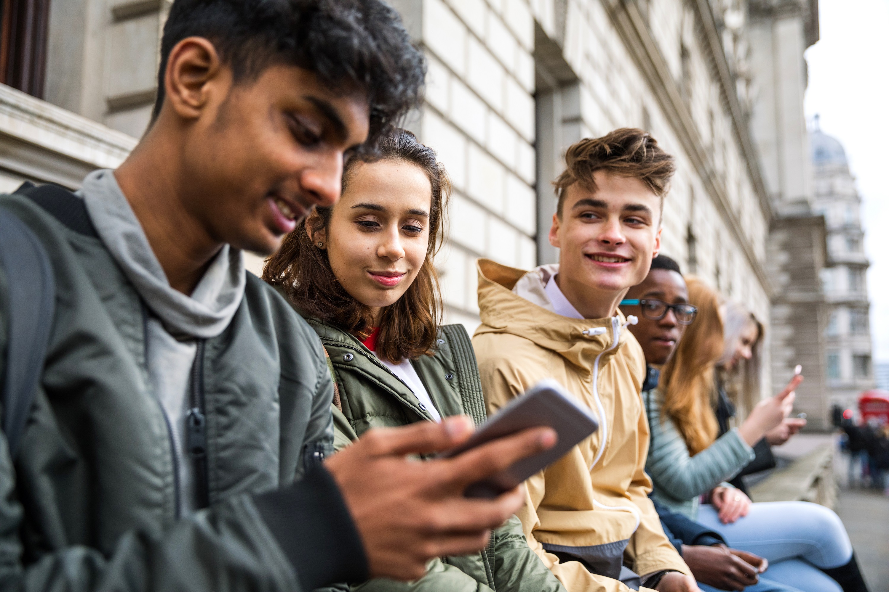 YE Trading Station – image of teenagers looking at mobile phones
