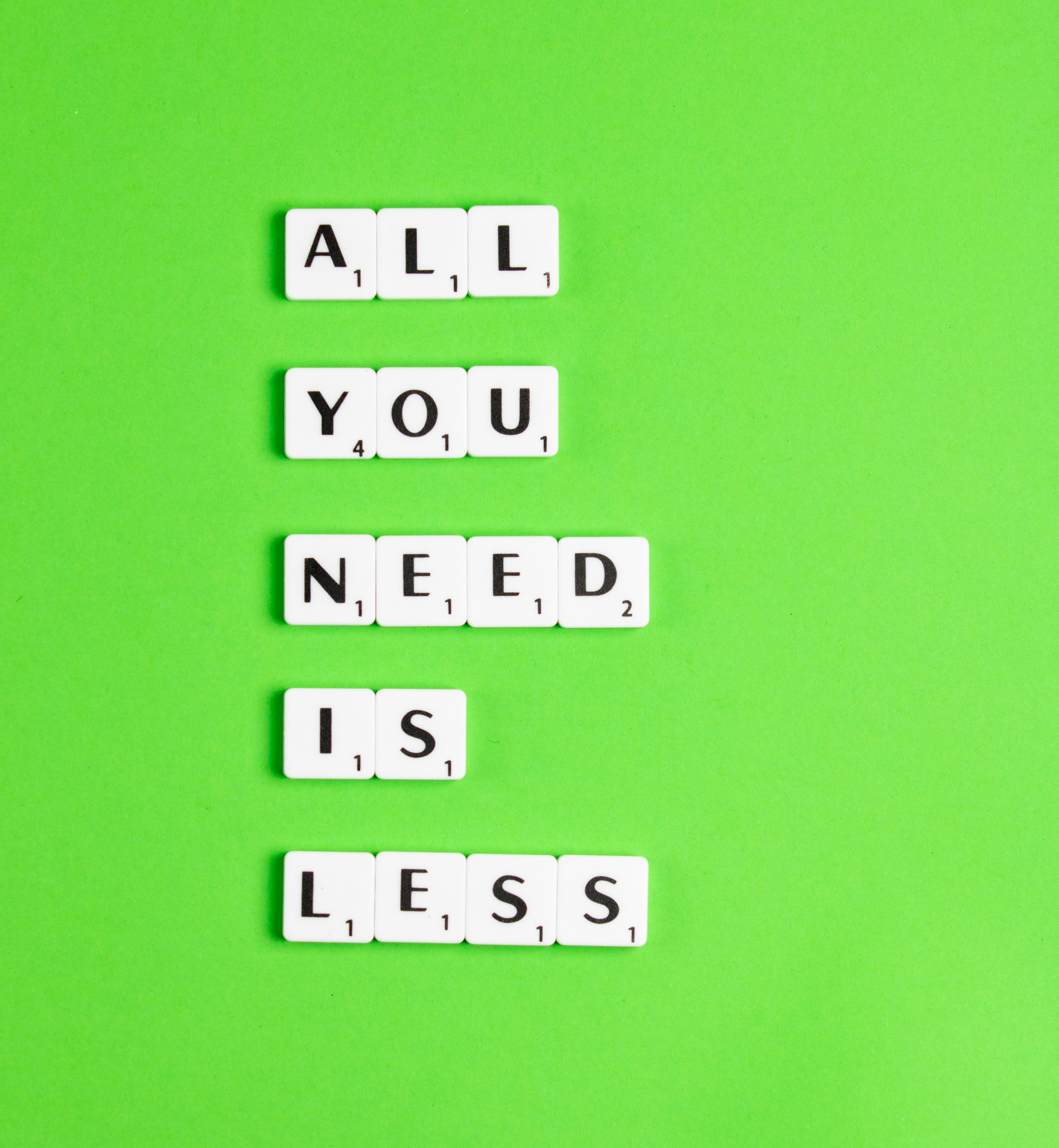 Scrabble tiles spelling out All you need is less