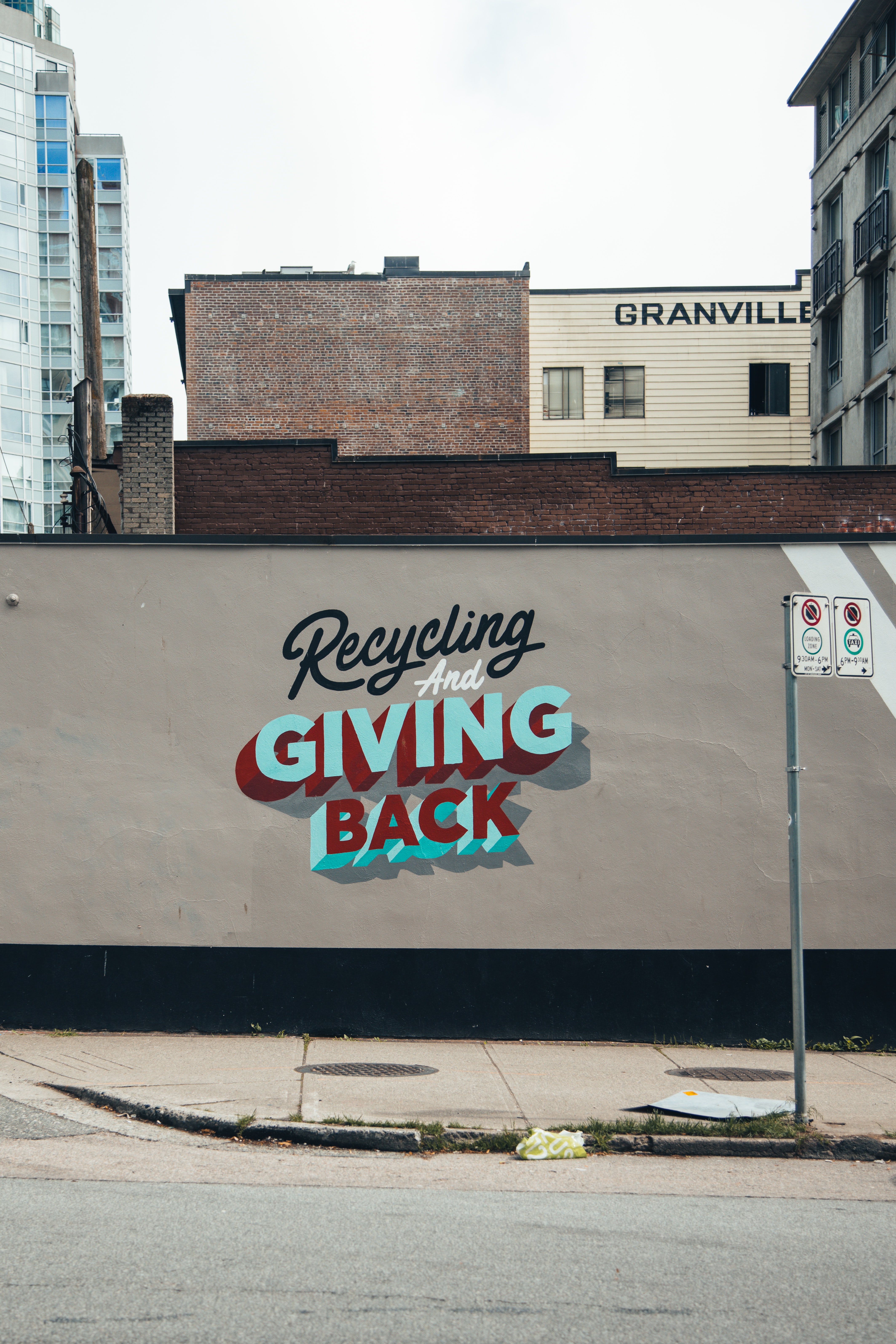 Street art wall painting reading Recycling and giving back