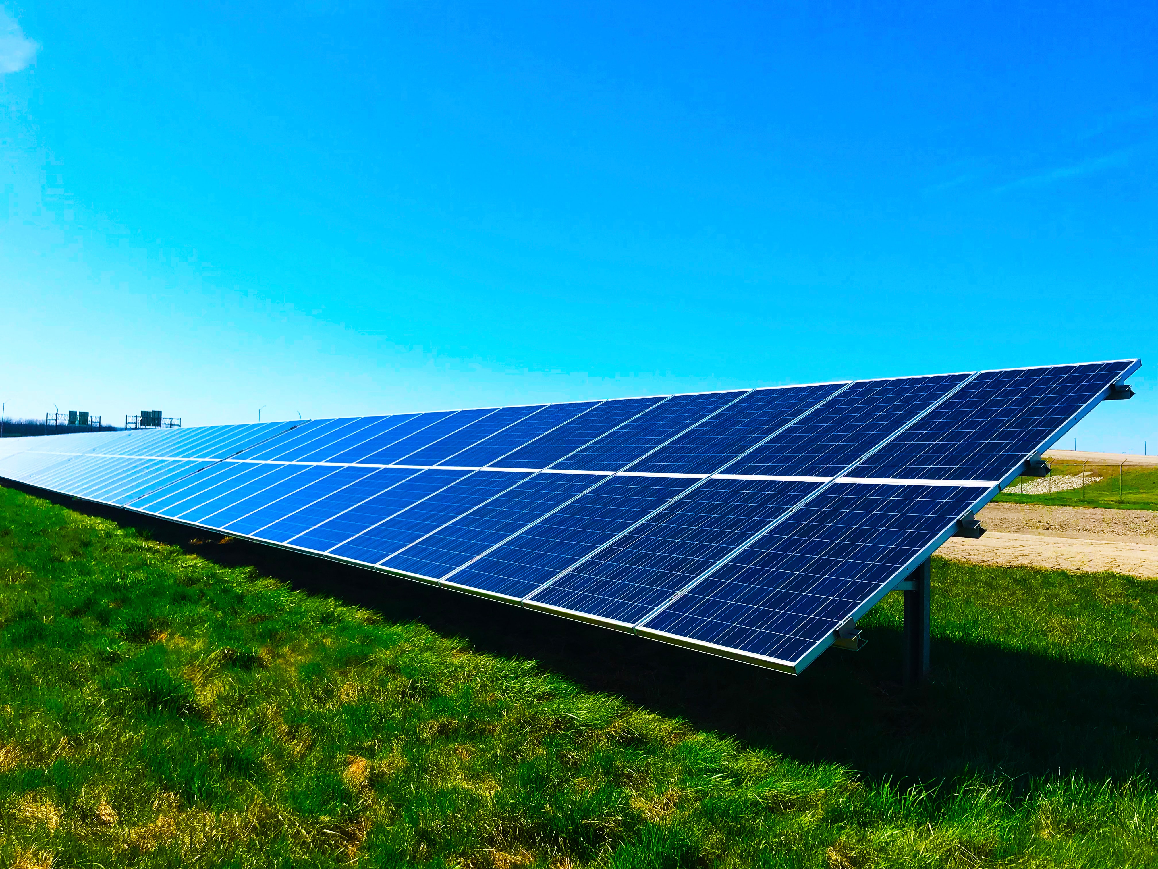 An array of solar panels in a field showing renewable energy generation for greater sustainability