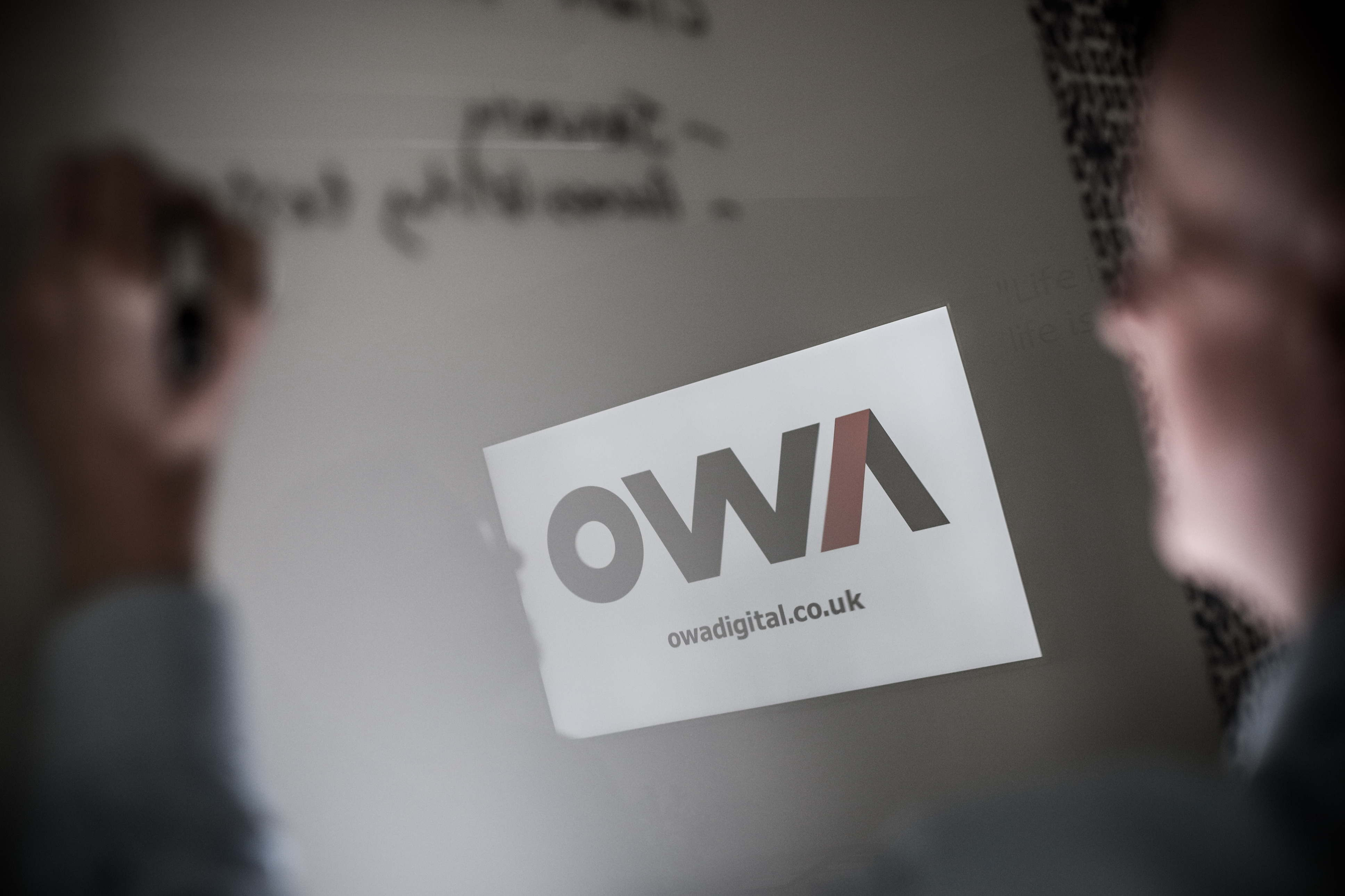 People in the foreground with OWA logo in the background.