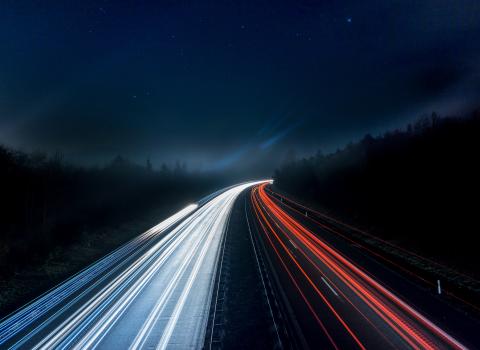 Road at nighttime showing car lights and route ahead from Drupal 7 to Drupal 9