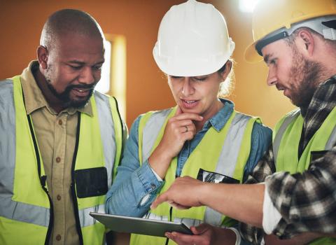 Ohutu - image of construction workers looking at plans for web application and mobile apps built by OWA