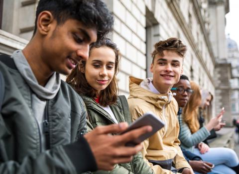 YE Trading Station – image of teenagers looking at mobile phones