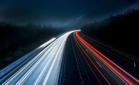 Long exposure photo of a highway at night, showcasing light trails and emphasizing Legacy System Support