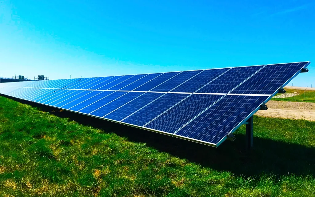 Solar panels installed in a green field, harnessing sunlight for renewable energy generation.