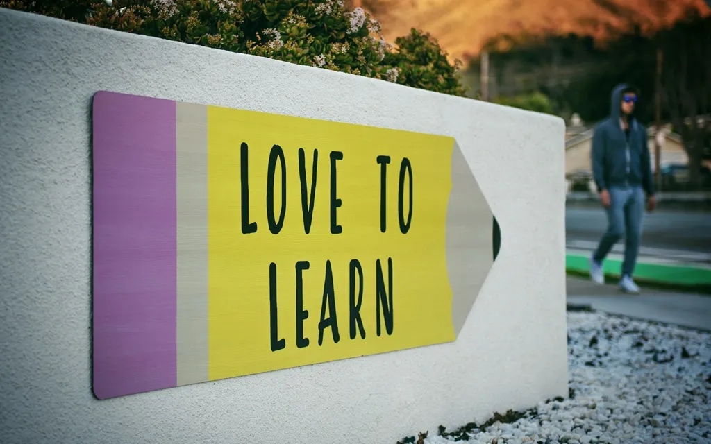 A close-up of a hand performing the "love to learn" sign in ASL, symbolizing a passion for education.