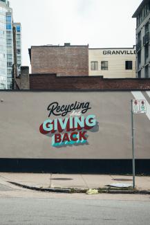 Street art wall painting reading Recycling and giving back